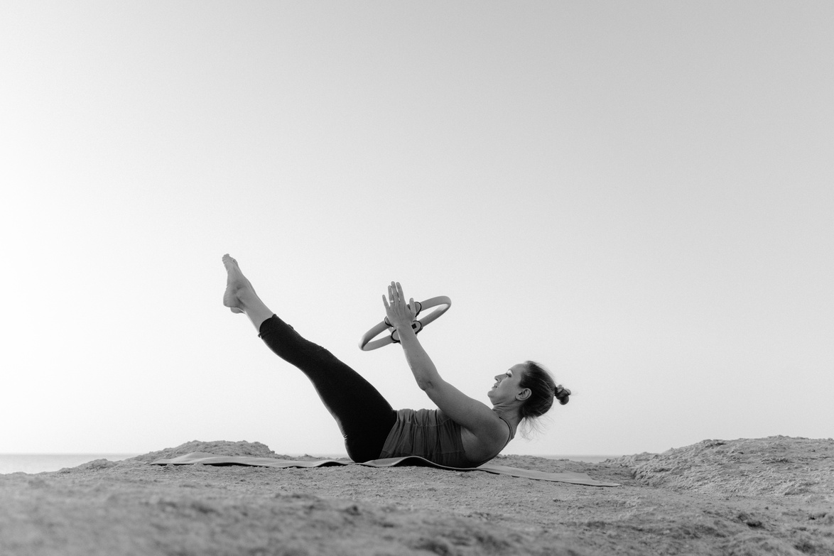 Grayscale Photo of Woman Using Pilates Ring 